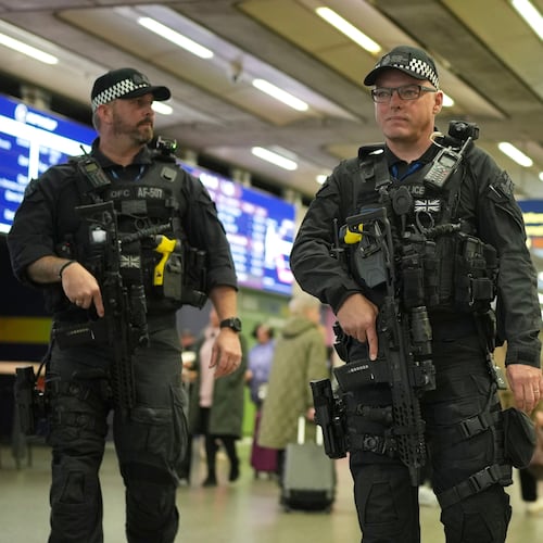 Armed police officers patrol the St Pancras International train station, in London, England, Monday, Nov. 3, 2025. (AP Photo/Kin Cheung)