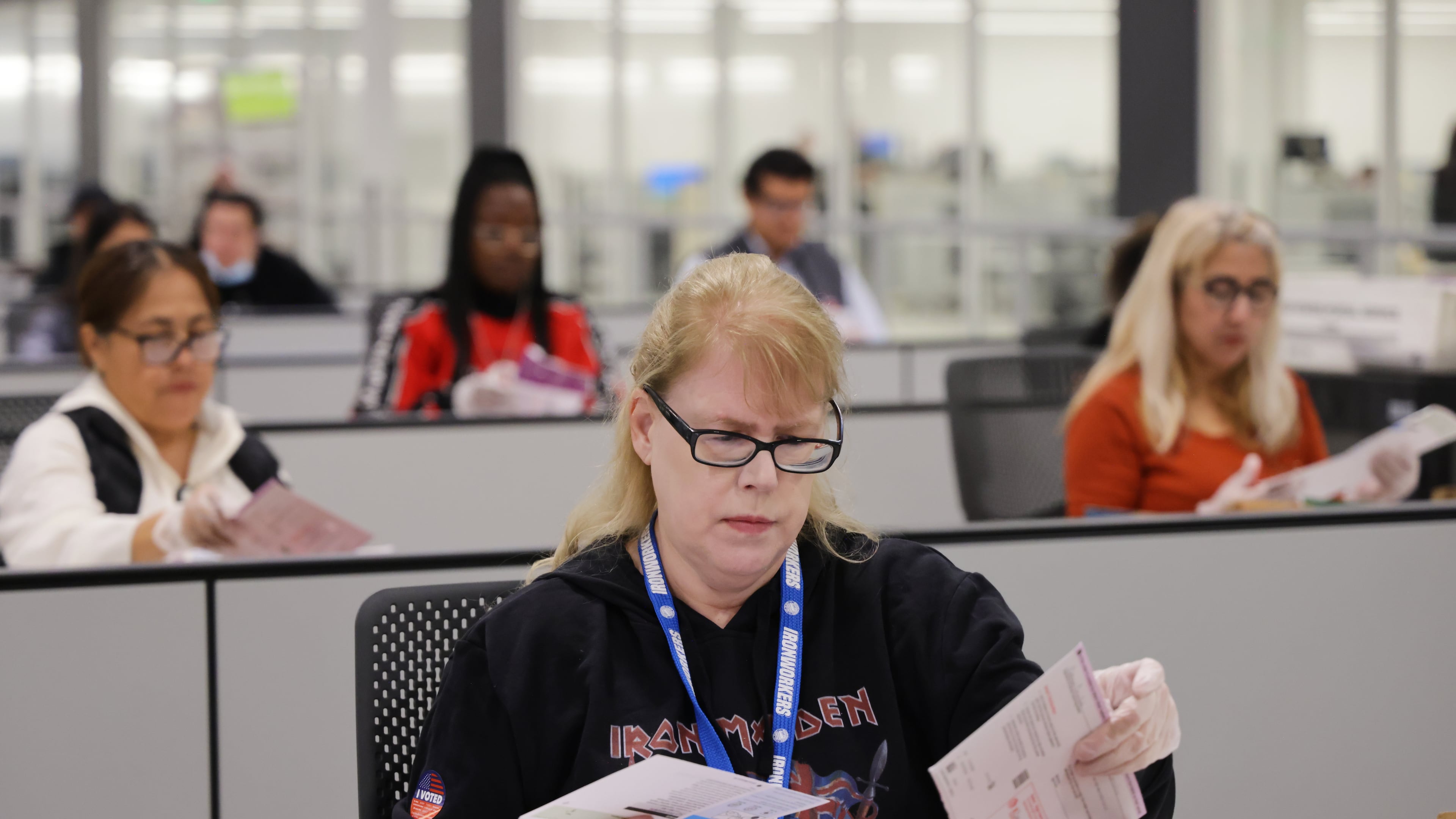 A worker examines ballots at the L.A. County Ballot Processing Center on Tuesday, Nov. 4, 2025, in City of Industry, Calif. (AP Photo/Ethan Swope)