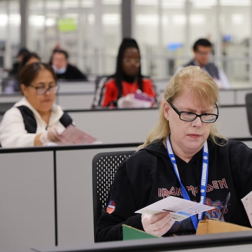 A worker examines ballots at the L.A. County Ballot Processing Center on Tuesday, Nov. 4, 2025, in City of Industry, Calif. (AP Photo/Ethan Swope)