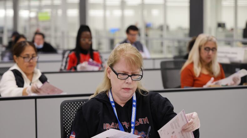 A worker examines ballots at the L.A. County Ballot Processing Center on Tuesday, Nov. 4, 2025, in City of Industry, Calif. (AP Photo/Ethan Swope)