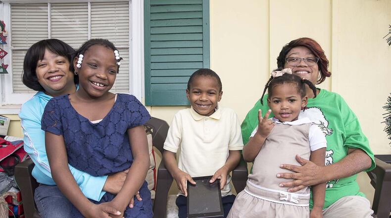 Twin sisters Priscilla (left) and Patricia (right) Moses have fostered more than 20 children, but now life revolves around their three adopted children: Ariah (from left), 9, Kristopher, 8, and Karrigan, 2.