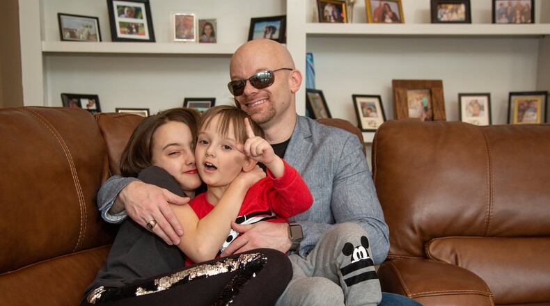 Chad Foster (right) plays with his daughter Juliana, 11, and son Jackson, 3, on the couch in his Marietta home. He is a blind man who is an amazingly successful business person, who skis downhill and who recently gave a motivational speech and his graduation from Harvard business school. After losing his eyesight in his late teens, Chad went on to generate over $45 billion in contracts in the business world currently working for Red Hat in Atlanta, one of the most innovative Tech companies and the world’s largest open source software company; develop software Oracle thought was impossible giving hundreds of millions of people the ability to earn a living by becoming the first to create customer relationship software for the visually impaired. (Photo by Phil Skinner)