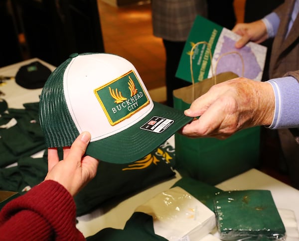 012422 Buckhead: Supporter Bob Prather (right) buys a Buckhead City hat from Tiffani Wittwer as he arrives for a Buckhead cityhood movement fundraiser on Monday, Jan. 24, 2022, in Buckhead. The Buckhead cityhood organization is starting a political action committee with $1 million in the bank, Buckhead City Committee chief executive Bill White told several hundred donors at Bistro Niko.   “Curtis Compton / Curtis.Compton@ajc.com”`