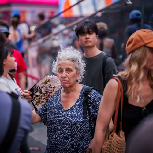 FILE - A person uses a fan as they wait in line to purchase Broadway tickets in Times Square, during a heat advisory in New York, May 19, 2026. (AP Photo/Adam Gray, File)