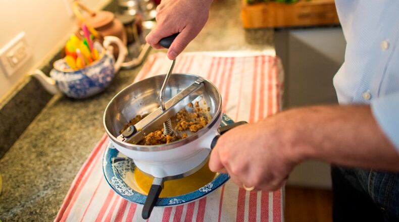 Allen Katz, founder of New York Distilling Company, demonstrates his Oxo food mill, a favorite kitchen tool, at his home in New York, Sept. 3, 2015. The mill has splayed feet, for resting atop a bowl, and three grades of stainless steel sieves, to achieve varying degrees of fineness for ingredients in soups and sauces.