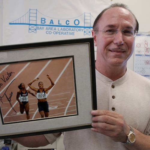FILE - BALCO founder Victor Conte holds up an autographed photo addressed to Conte of track star Marion Jones in his office in Burlingame, Calif., Oct. 21, 2003. (AP Photo/Paul Sakuma, File)