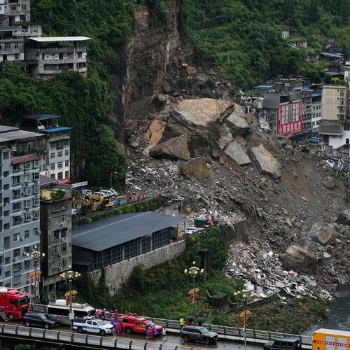 Rescuers stand by along the bridge as they prepare to conduct a search and rescue operation at the scene of a landslide in Pengshui County in southwestern China's Chongqing on Saturday, July 18, 2026. (AP Photo/Andy Wong)