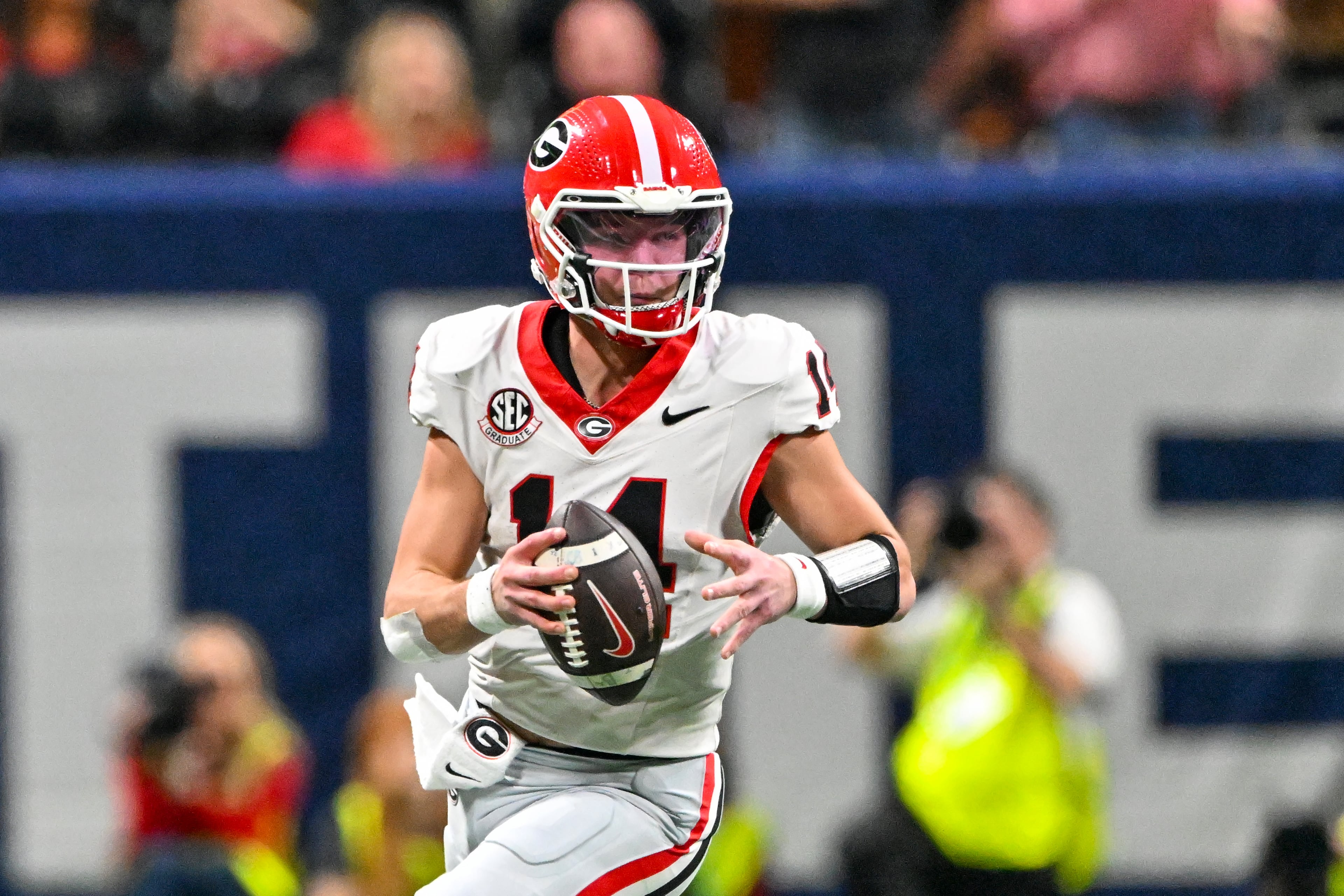 Georgia quarterback Gunner Stockton (14) rolls out to pass against Alabama during the second quarter of the SEC Championship game at Mercedes-Benz Stadium, Saturday, Dec. 6, 2025, in Atlanta. (Hyosub Shin / AJC)