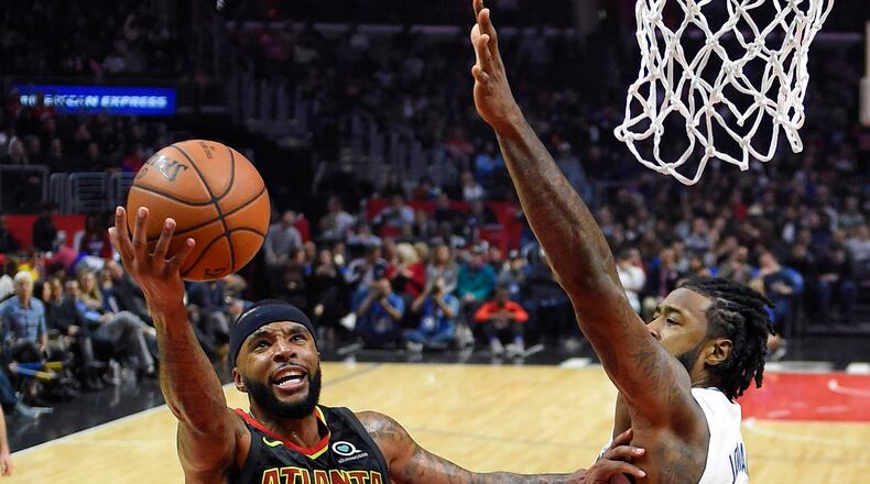Atlanta Hawks guard Malcolm Delaney, left, shoots as Los Angeles Clippers center DeAndre Jordan defends during the second half of a basketball game, Monday, Jan. 8, 2018, in Los Angeles. The Clippers won 108-107. (AP Photo/Mark J. Terrill)