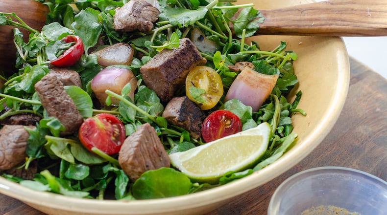 Shaking Beef is a traditional Vietnamese dish made with watercress, tomatoes and marinated sirloin. (Virginia Willis for The Atlanta Journal-Constitution)