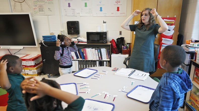 Jennifer Henderson, lead literacy center teacher, works on a word “stretching” activity at Charles R. Drew Charter School. It helps students break words into sounds.