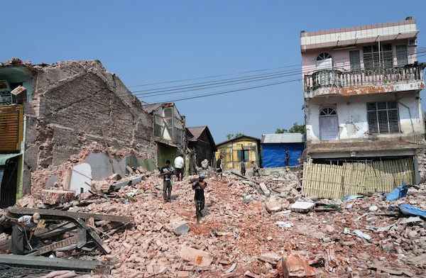 Volunteers help to clear collapsed building after one month of the strong earthquake in Naypyitaw, Myanmar, Monday, April 28, 2025. (AP Photo/Aung Shine Oo)