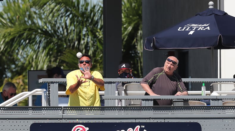 A Braves fan in the Tomahawk Tiki Bar & Grill, located beside left field in CoolToday Park, catches a batted ball during the first full-squad workout Tuesday. (Curtis Compton/Atlanta Journal-Constitution)