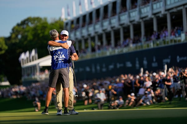 Scottie Scheffler hugs his caddie Ted Scott after winning the PGA Championship golf tournament at the Quail Hollow Club, Sunday, May 18, 2025, in Charlotte, N.C. (AP Photo/George Walker IV)