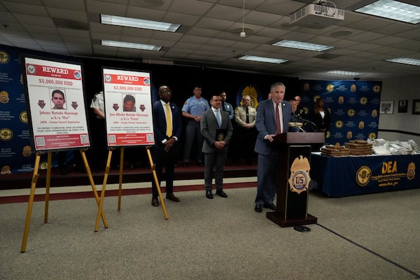 Images of Johnny Hurtado Olascoaga and Jose Alfredo Hurtado Olascoaga, who are accused of participating in a conspiracy to manufacture cocaine, heroin, methamphetamine and fentanyl and conspiracy to import and distribute the drugs in the United States, are displayed during a news conference Tuesday, April 15, 2025, in Atlanta. (AP Photo/Brynn Anderson)