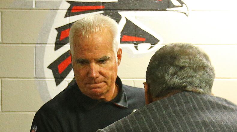 Following his final press conference as Falcons head coach Sunday, Mike Smith is greeted by owner Arthur Blank. Blank fired Smith Monday.