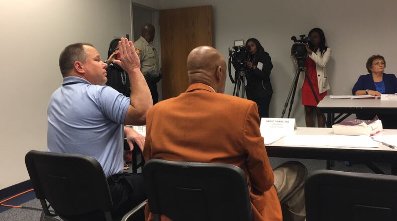 Gwinnett County Commissioner Tommy Hunter, left, takes an oath before declining to answer questions during the Gwinnett County ethics board’s Wednesday morning hearing. TYLER ESTEP / TYLER.ESTEP@AJC.COM