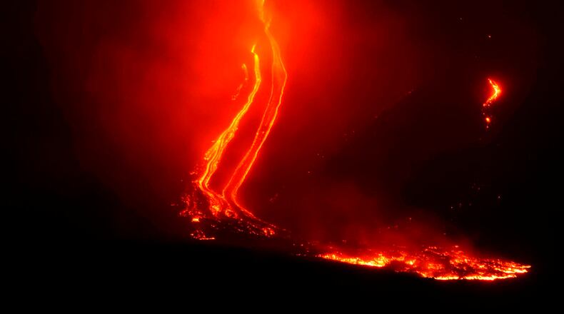 Mount Etna volcano spews lava during an eruption early Tuesday Dec. 25, 2018. Italy's Catania airport is reopening after an ash cloud from Mount Etna's latest eruptions forced it to shut down. The airport on the Mediterranean island of Sicily says it's having a limited opening Tuesday, operating four flights an hour. (Orietta Scardino/ANSA via AP)