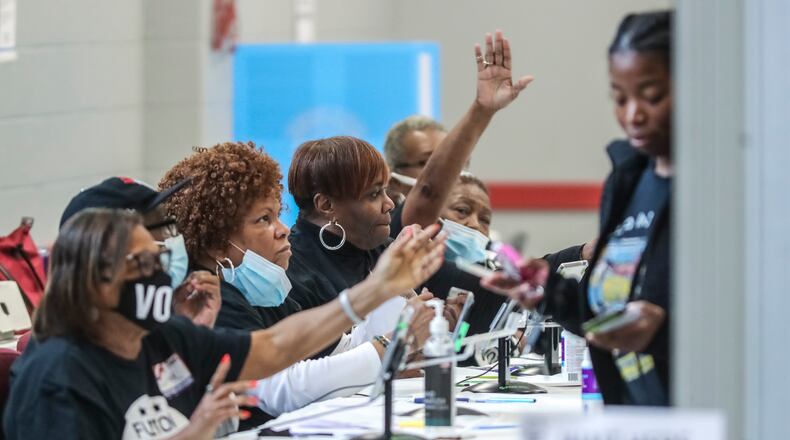 Poll workers check voters' identification on Tuesday, Dec. 6, 2022 at the C.T. Martin Natatorium and Recreation Center in Atlanta. (John Spink/AJC)