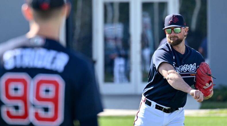 Braves relief pitcher Kirby Yates (right) and starting pitcher Spencer Strider (foreground) toss a baseball Saturday. (Hyosub Shin / Hyosub.Shin@ajc.com)