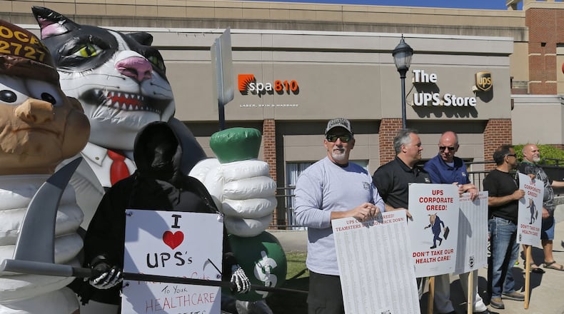 UPS aircraft mechanics hold a protest outside a UPS Store in Atlanta on Tuesday as they push to keep their level of health benefits in contract negotiations. BOB ANDRES /BANDRES@AJC.COM