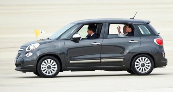 FILE - Pope Francis waves from inside a Fiat 500 as he departs Andrews Air Force Base in Md, Tuesday, Sept. 22, 2015. (AP Photo/Susan Walsh, File)