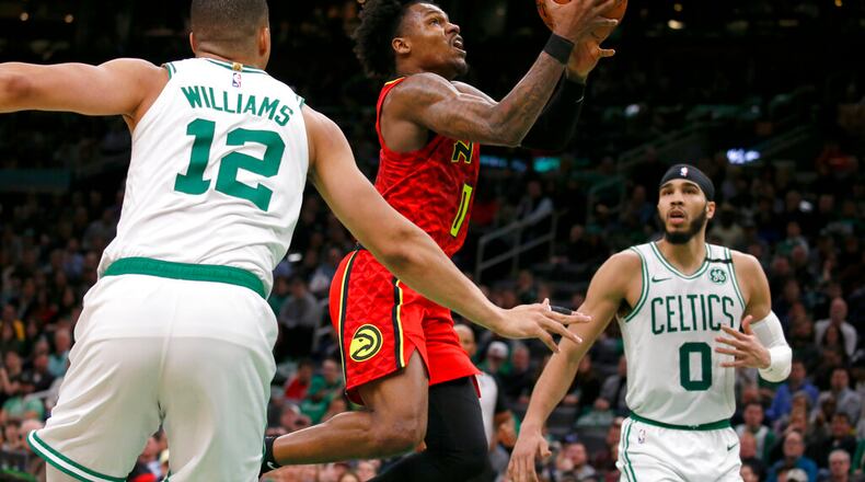Hawks guard Brandon Goodwin drives to the basket between Boston Celtics forward Grant Williams (12) and forward Jayson Tatum (0) during the second half of an NBA basketball game, Friday, Feb. 7, 2020, in Boston. (AP Photo/Mary Schwalm)