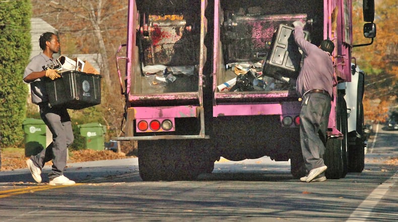 Sanitation workers pick up recyclable materials in Atlanta’s Candler Park/Inman Park area. Atlanta-based waste disposal technology firm Rubicon is helping the city gauge the impact of its recycling efforts with new mobile technology that collects varioius data on recyling while garbage trucks are on their routes. AJC File Photo