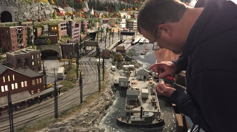 A worker puts the final touches on a New England section of Gulliver's Gate, a miniature world depicting hundreds of landmarks, settings and events, in Times Square. (Lori Rackl/Chicago Tribune/TNS)