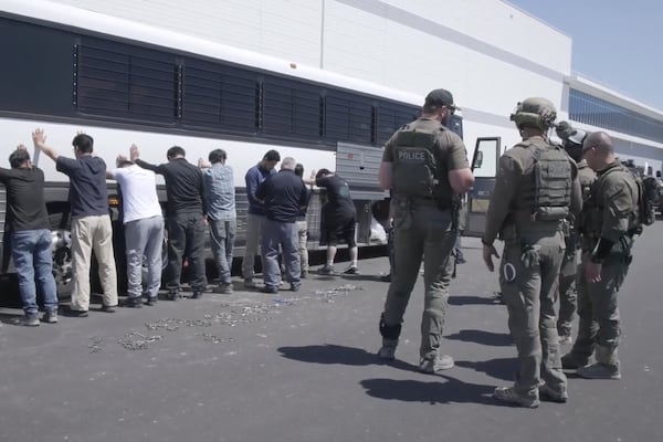 Manufacturing plant employees wait to have their legs shackled at the Hyundai Motor Group’s electric vehicle plant, Thursday, Sept. 4, 2025, in Ellabell, Ga. (Corey Bullard/U.S. Immigration and Customs Enforcement via AP)