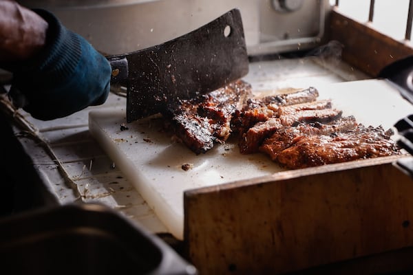 Oscar Wyatt chops ribs at Sgt. Wyatt’s Country BBQ in Atlanta’s Kirkwood neighborhood. The restaurant still uses the same barbecue sauce recipe the senior Wyatt and his brother created decades ago. (Natrice Miller/AJC)