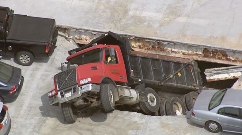 A dump truck has partially fallen through the roof deck of a parking garage in Massachusetts.