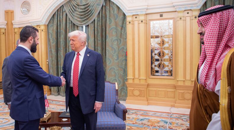 FILE - In this photo provided by the Saudi Royal Palace, Syria's interim President Ahmad al-Sharaa, left, shakes hands with U.S. President Donald Trump in Riyadh, Saudi Arabia, Wednesday, May 14, 2025. At foreground right is Saudi Crown Prince Mohammed bin Salman. (Bandar Aljaloud/Saudi Royal Palace via AP, File)