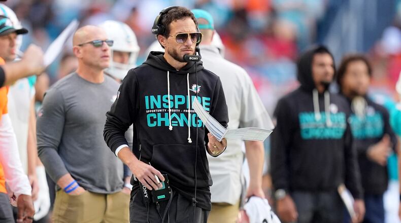 Miami Dolphins head coach Mike McDaniel, center, looks on during the first half of an NFL football game against the Tampa Bay Buccaneers, Sunday, Dec. 28, 2025, in Miami Gardens, Fla. (AP Photo/Rebecca Blackwell)