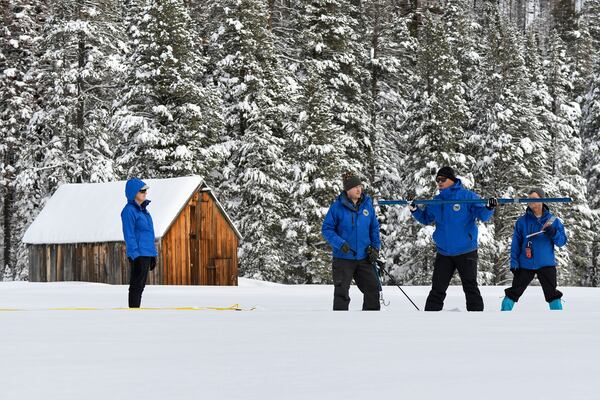 FILE - In this photo provided by the California Department of Water Resources, forecasting chief Sean de Guzman, second from right, and engineers work the measurement phase of the first media snow survey of the season at Phillips Station in the Sierra Nevada Mountains, Calif., Jan. 3, 2023. (Kenneth James/California Department of Water Resources via AP)