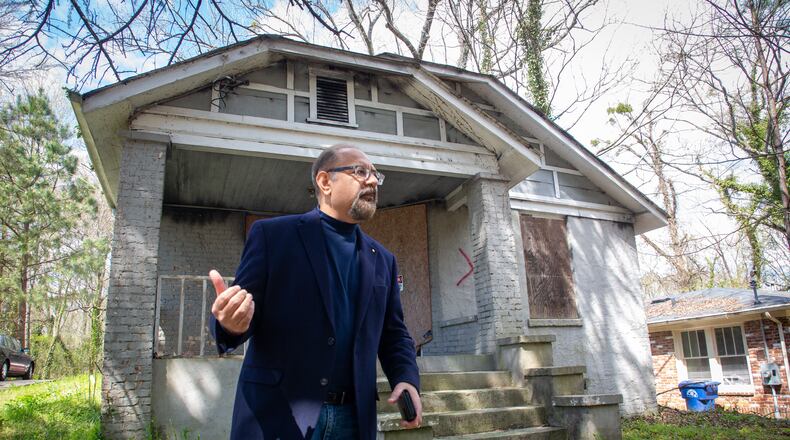 Swapan Kumar stands in front of a house he owns in southwest Atlanta home that the city has marked for demolition Friday, March 25, 2022.  STEVE SCHAEFER FOR THE ATLANTA JOURNAL-CONSTITUTION