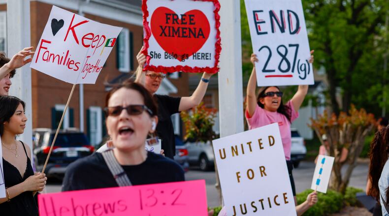 Dozens of protesters gather at a busy intersection to show support for 19-year-old Ximena Arias-Cristobal and her father, Jose Francisco Arias-Tovar, who are now in ICE custody, in Dalton on Wednesday. (Miguel Martinez/AJC)