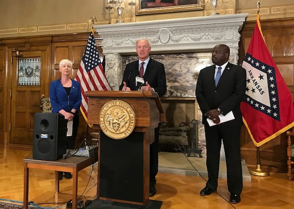 FILE - In this Sept. 12, 2018, file photo, Arkansas Gov. Asa Hutchinson, center, talks at a news conference at the State Capitol in Little Rock, Ark., about the state's work requirement for its expanded Medicaid program. (AP Photo/Andrew DeMillo, File)
