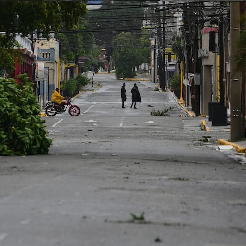 People walk in Kingston, Jamaica, as Hurricane Melissa approaches, Tuesday, Oct. 28, 2025. (AP Photo/Matias Delacroix)