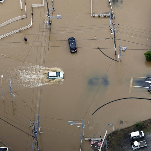Cars make their way through flooded road after heavy rain in Oamishirasato, Chiba prefecture, Japan, Friday, Aug. 14, 2026. (Kota Endo/Kyodo News via AP)