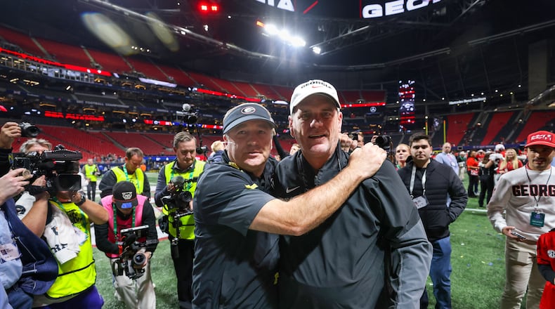 Georgia head coach Kirby Smart (left) celebrates with offensive coordinator Mike Bobo after a 28-7 victory over Alabama in the SEC Championship game at Mercedes-Benz Stadium, Saturday, Dec. 6, 2025, in Atlanta. (Jason Getz/AJC)