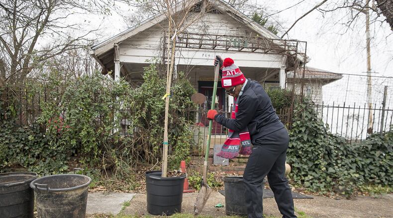 Eugenia Pryor of Ellenwood digs a hole for a crape myrtle tree that she and other volunteers planted Tuesday along English Avenue outside the Salvation Army Bellwood Boys and Girls Club in Atlanta. “I spent many days in the garden with my mom,” Pryor said as she chipped away at the hard earth.