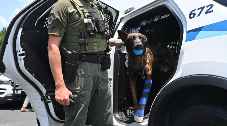 Gwinnett County police Cpl. Aaron Carlyle pets K-9 Kai, who was shot multiple times during an domestic-related incident May 23. Kai was released from North Georgia Veterinary Specialists in Buford on Tuesday, June 14.