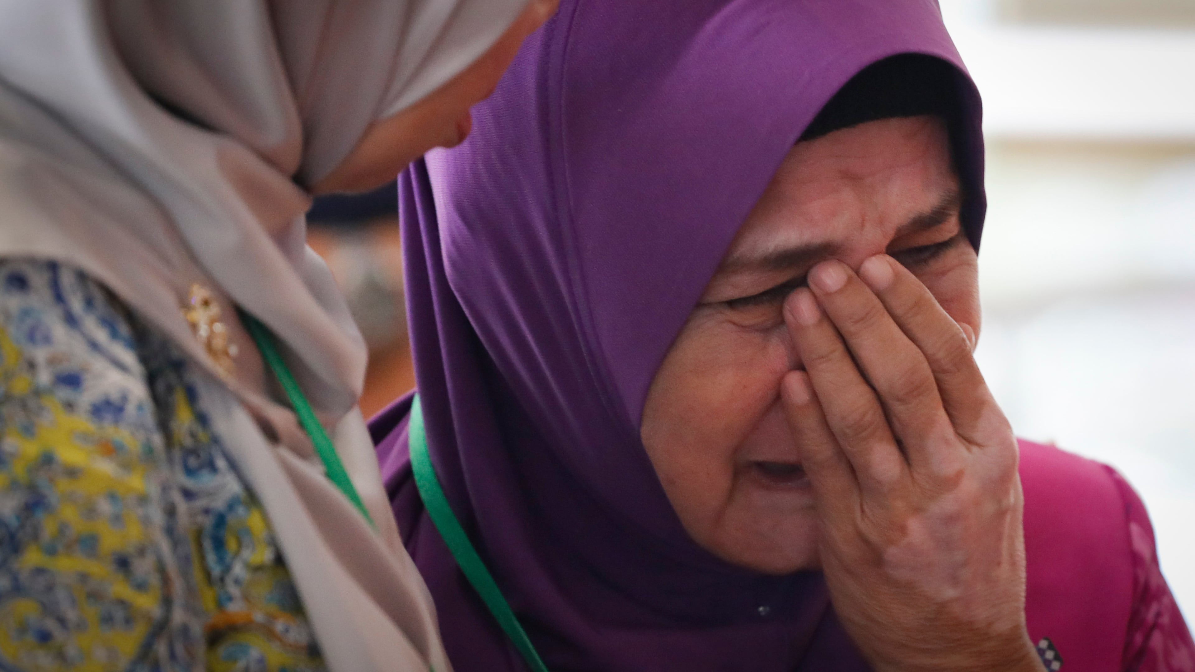 FILE -Sarah Nor, the mother of Norliakmar Hamid, a passenger on missing Malaysia Airlines flight MH370, cries after she attended a briefing on the final investigation report on missing flight MH370 in Putrajaya, July 30, 2018.(AP Photo/Vincent Thian, File)