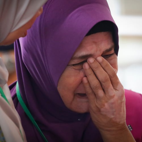FILE -Sarah Nor, the mother of Norliakmar Hamid, a passenger on missing Malaysia Airlines flight MH370, cries after she attended a briefing on the final investigation report on missing flight MH370 in Putrajaya, July 30, 2018.(AP Photo/Vincent Thian, File)