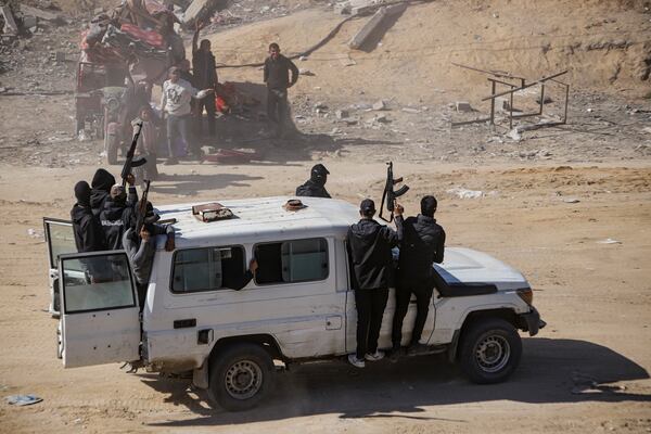 FILE - Hamas fighters secure aid trucks in Rafah, Gaza Strip, Tuesday, Jan. 21, 2025, days after a ceasefire between Hamas and Israel went into effect. (AP Photo/Jehad Alshrafi, File)