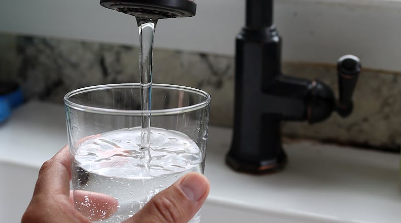 A file photo shows tap water filling a glass. The north Georgia city of Calhoun, which has been home to flooring and carpet manufacturing for decades, is facing multiple lawsuits alleging sewage sludge from its wastewater treatment plant has contaminated land and water in the area with toxic “forever chemicals.” (Justin Sullivan/Getty Images/TNS)