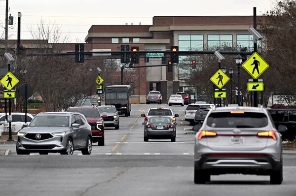 Traffic makes it way down Main Street in front of Tucker High School in January. (Hyosub Shin/AJC)