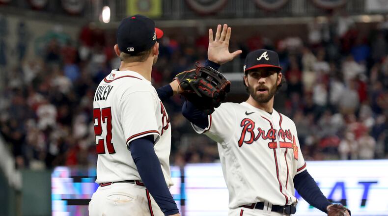 Atlanta Braves third baseman Austin Riley (27) is congratulated by shortstop Dansby Swanson (7) after a catch against the Philadelphia Phillies along the left field wall during the ninth inning of Game 2 of the National League Division Series at Truist Park in Atlanta on Oct. 12, 2022. (Jason Getz / Jason.Getz@ajc.com)