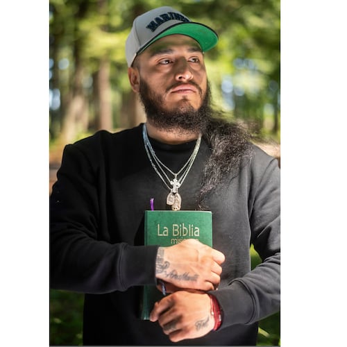 Gabriel Martinez Garcia, 30, holds a Bible close to his chest as tattoos of his parents are visible on his wrists, in Tenino, Wash., on Sunday, June 14, 2026. (AP Photo/Akash Pamarthy)